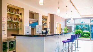 A modern bar area with a counter, bar stools, and shelves with bottles. - ibis Bursa (Bursa)