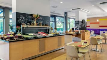 Un café moderno con barra para desayunos, zona de estar y grandes ventanales.