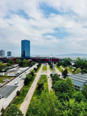 A cityscape with a prominent modern building, a parking lot with RVs, and a green park area. - ibis Bursa (Bursa)