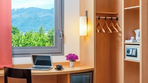 A room with a desk, laptop, and a view of mountains through a window. - ibis Bursa (Bursa)