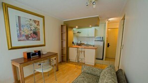A compact living space with a kitchenette, a dining area, and a sofa. - RQ City Center (Santiago)