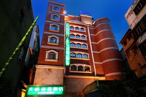 Vista frontal de la propiedad por la tarde o noche