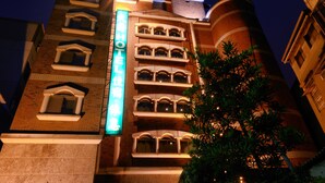 A hotel with multiple balconies and a prominent vertical sign.