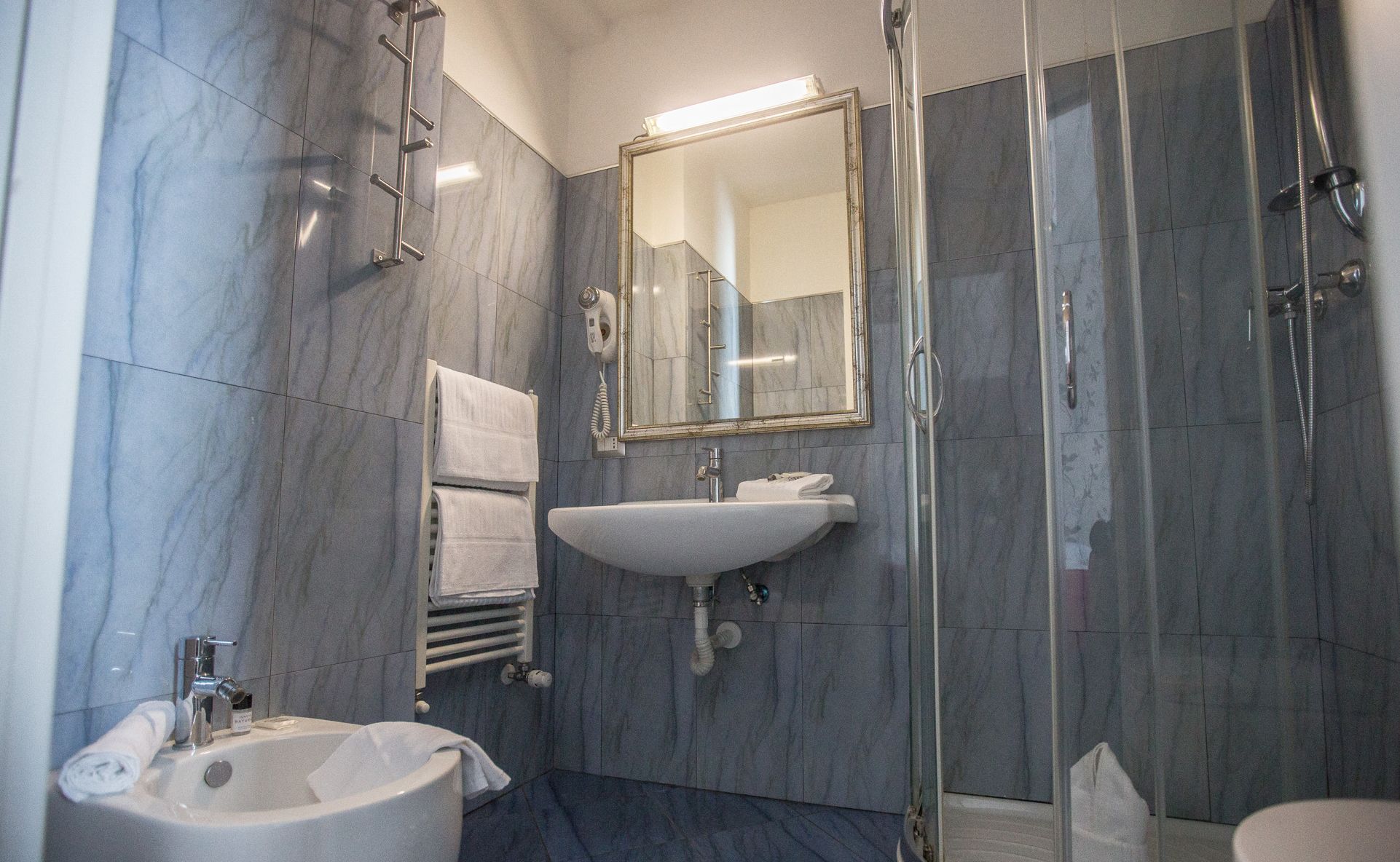 Une salle de bain moderne avec un lavabo, un miroir et une douche.