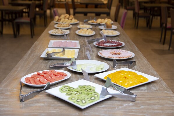 A buffet table with various food items and serving utensils.
