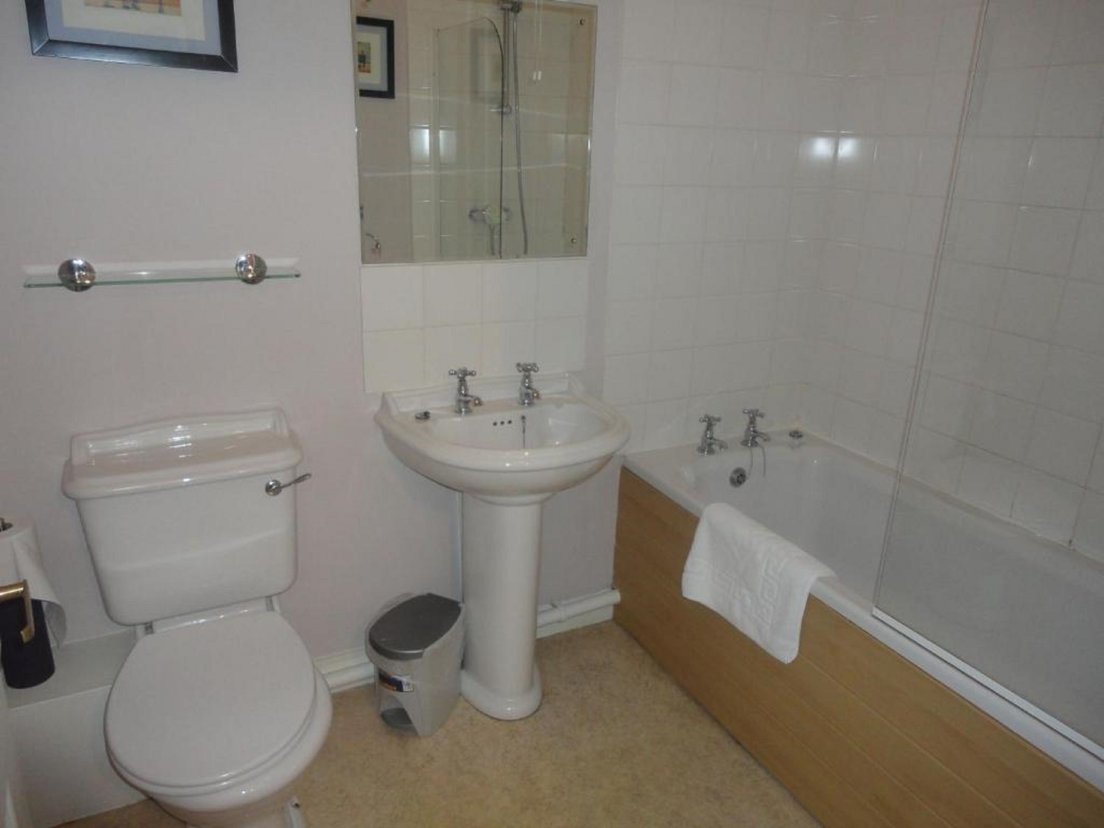 A bathroom with a toilet, sink, and bathtub.