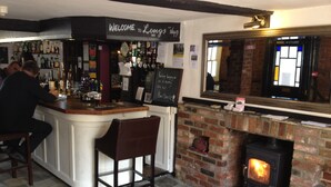 A bar area with a fireplace, stone flooring, and a sign reading "Welcome to Long's Inn 1649". - Longs Inn (Milton Keynes)