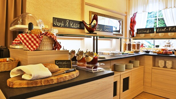 A breakfast buffet with a variety of food items and a sign indicating 'Walnuss Brot'. - Hotel Restaurant Ruppert (Walluf)