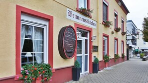 A building with a sign reading "Brunnenstuben" and a chalkboard menu.