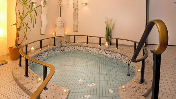 A spa area with a circular pool, stone railings, and candles.