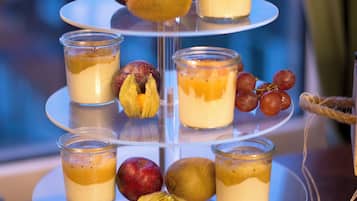 Un expositor de postres de varios niveles con frutas y dulces.