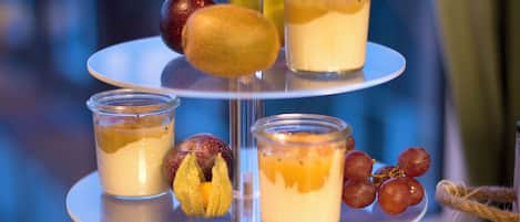 Un expositor de postres de varios niveles con frutas y dulces.