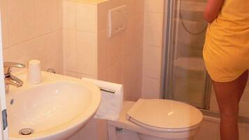 A bathroom with a sink, toilet, and shower.