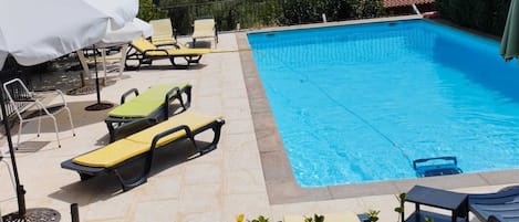 Piscine extérieure, parasols, chaises longues