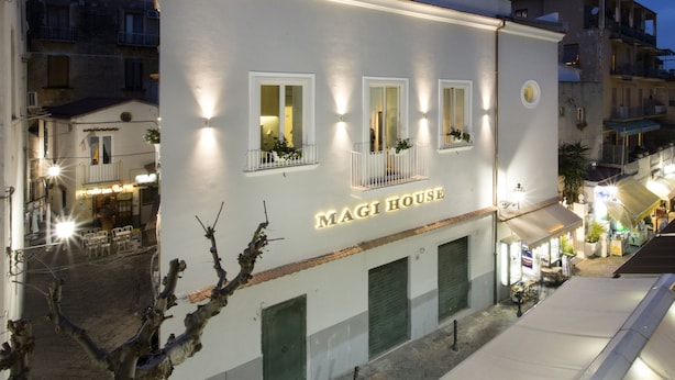 A building with the sign "MAGI HOUSE" indicating a hotel. There are multiple windows with balconies, and the building has a flat roof with a metal railing. - Magi House Relais (Sorrento)