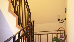 A staircase with a black metal railing and terracotta tiles. - Gaestehaus Loschwitz (Dresden)