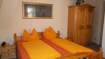 Ein Schlafzimmer mit Doppelbett, Holz-Kopfteil, Nachttisch, Schrank und einem Bild an der Wand.