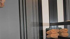 A bathroom with a black sink, a towel rack with folded towels, and a striped curtain. - Gaestehaus Loschwitz (Dresden)