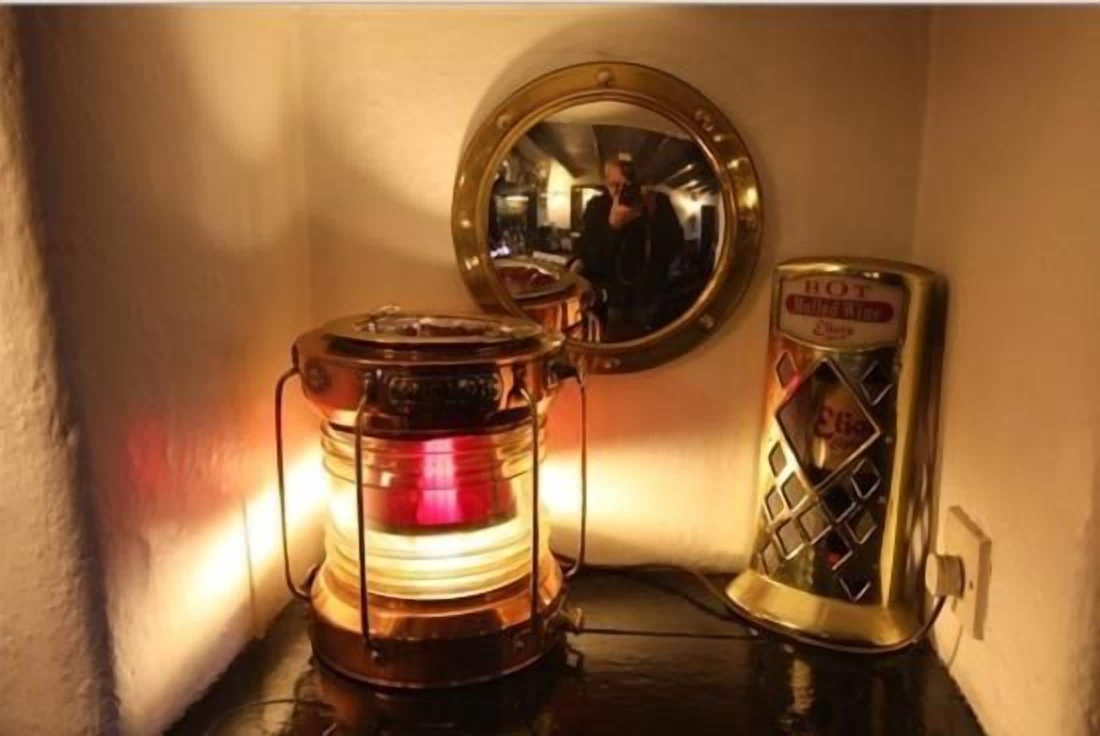 A room corner with a vintage-style heater, a mirror, and a decorative item.