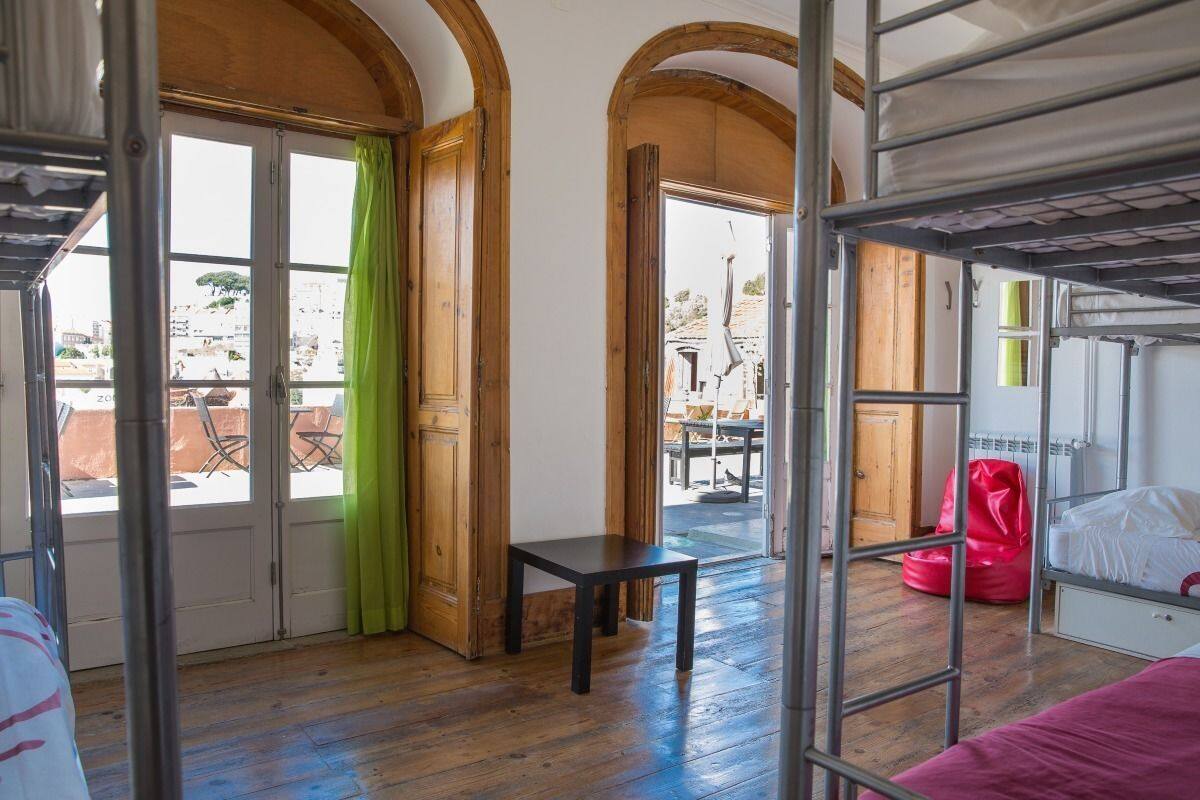 Una habitación con literas, una mesita pequeña y vista al exterior.
