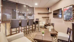 A restaurant with a checkered floor, wooden furniture, and a large framed menu on the wall. - Brit Hotel La Cote Des Havres (Lessay)