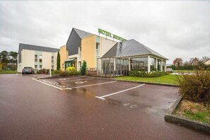 Hotel Restaurant offers a modern architectural design with a flat roof and ample parking.