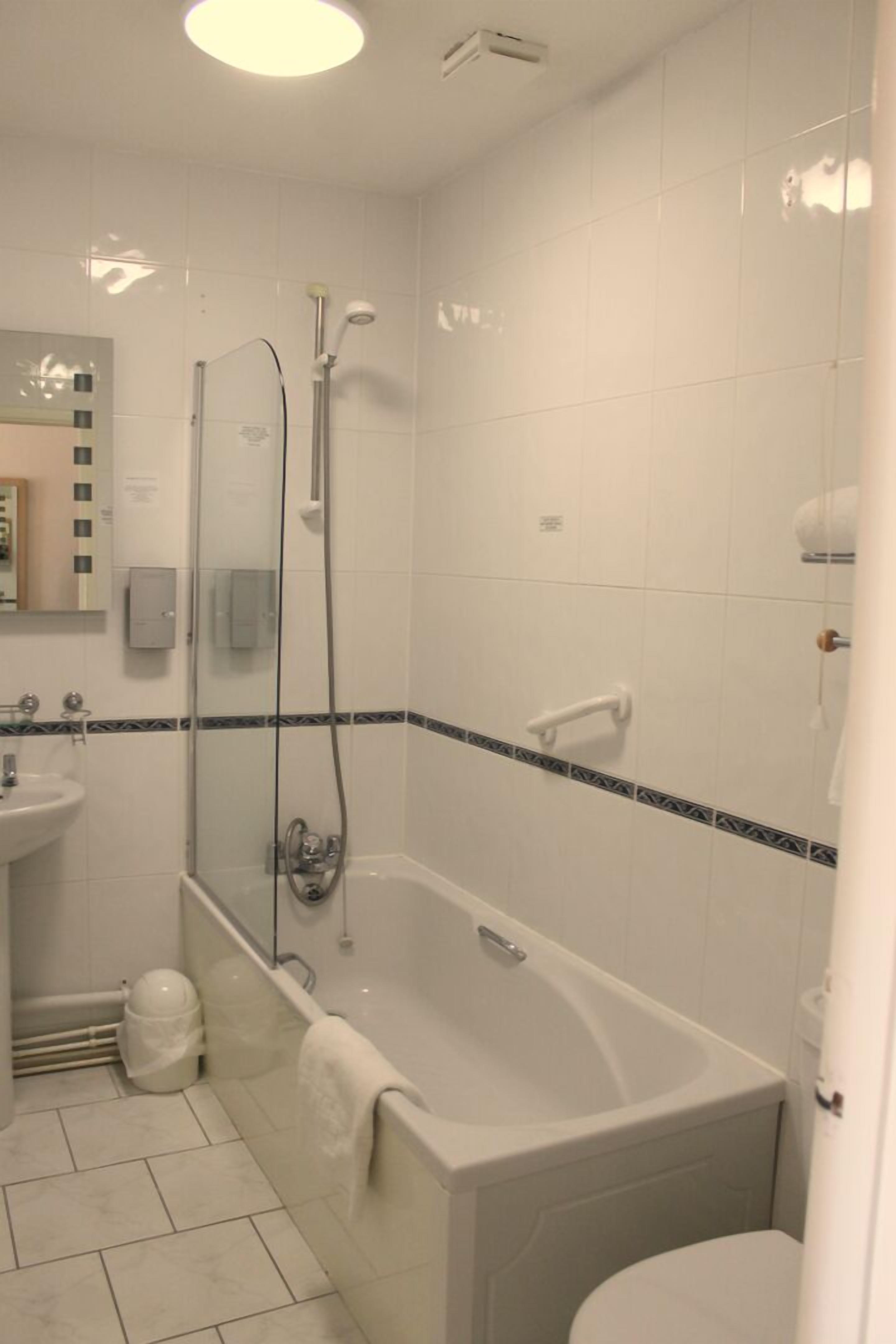 A bathroom with a bathtub, a sink, and a toilet.