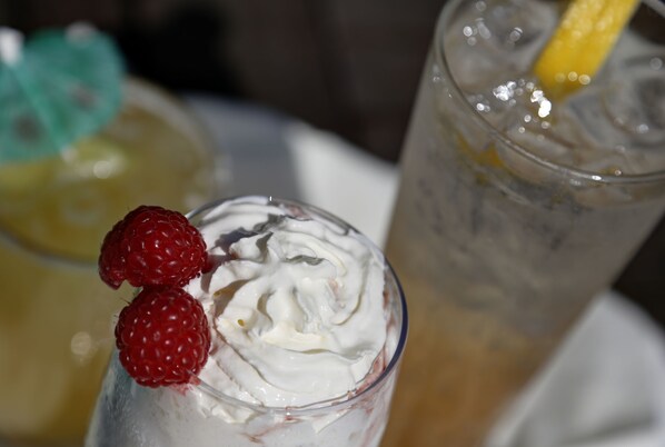 A glass with whipped cream and raspberries.