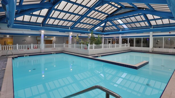 An indoor swimming pool with a glass ceiling, clear poolside railing, and a no diving sign. - Best Western Weymouth Hotel Rembrandt (Weymouth)