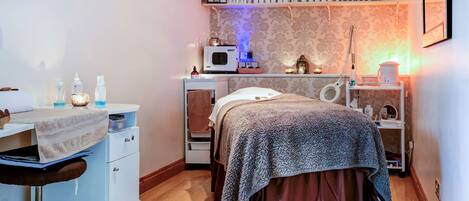 Un dormitorio con cama, escritorio y estanterías con artículos de aseo.