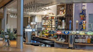 A bar area with a tap system, shelves of liquor bottles, and a display of beer taps. - Best Western Weymouth Hotel Rembrandt (Weymouth)