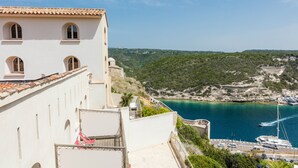 A coastal building with a balcony overlooking a marina and a clear view of the sea. - Hotel Genovese (Bonifacio)