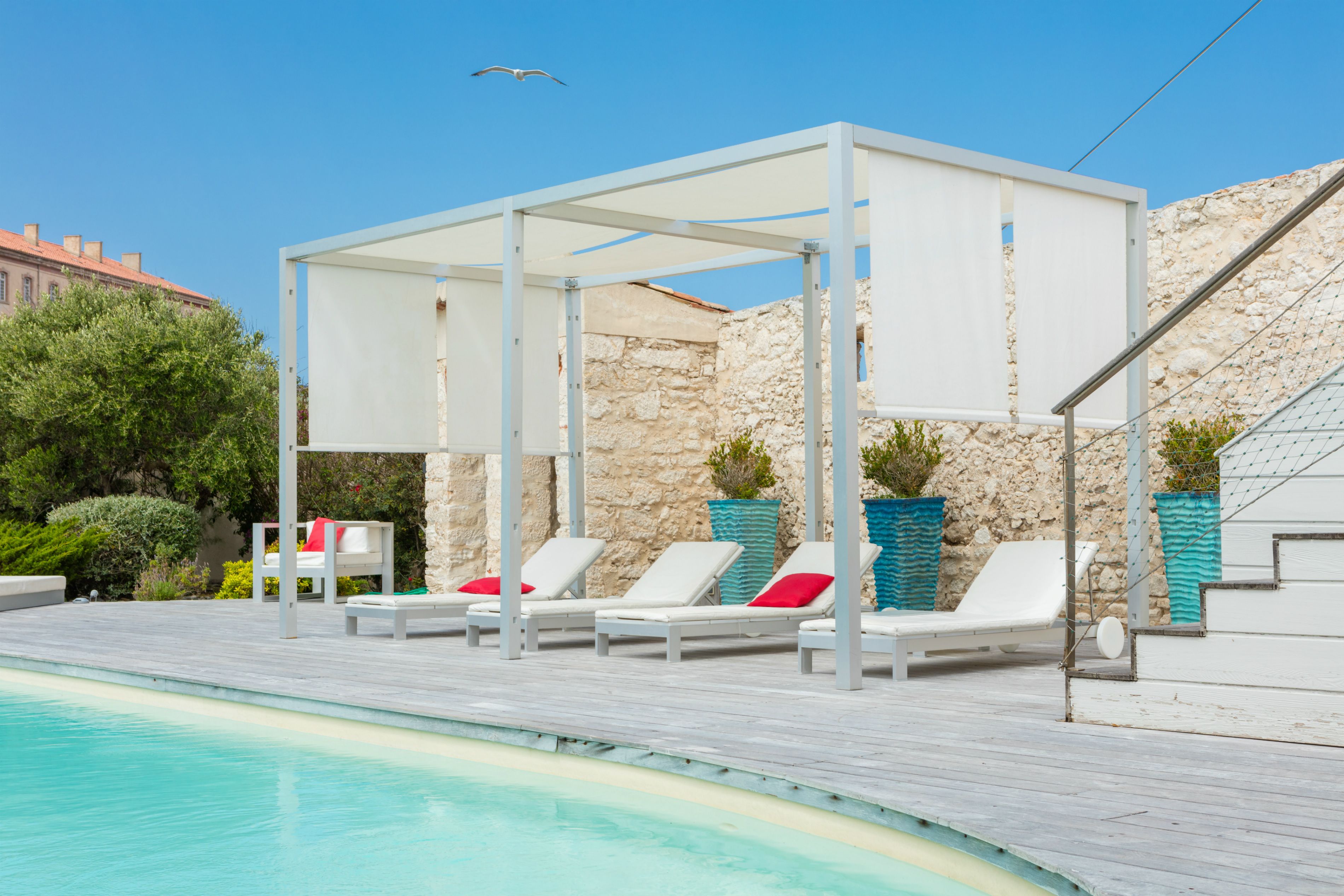 A poolside area with lounge chairs and a pergola.