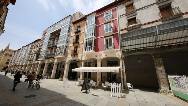 Un hotel con toldo blanco, mesas al aire libre y un cartel que dice 'Hotel Carvesella El Puinto'.
