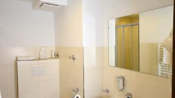 A modern bathroom with a toilet, sink, and mirror.