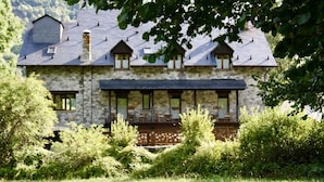 A stone house with a balcony and a covered porch. - Hotel Casa Arcas (Villanova)