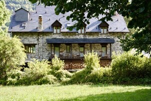 Una casa de piedra con balcón y porche cubierto.