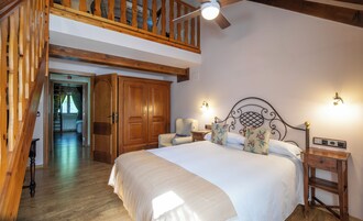 Un dormitorio con una cama grande, un armario de madera y una zona superior con una escalera de madera.