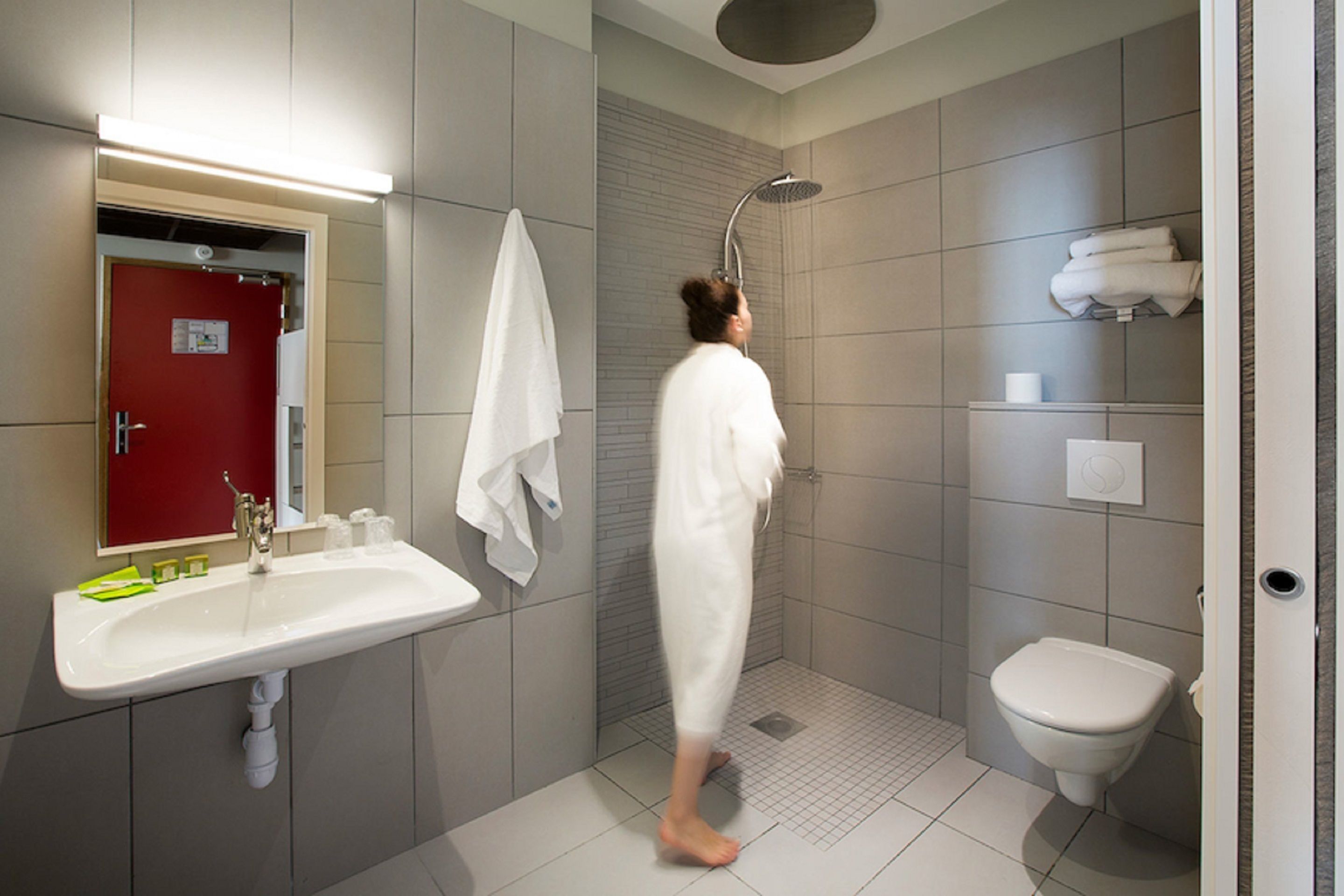 Un baño moderno con ducha, inodoro y lavamanos.
