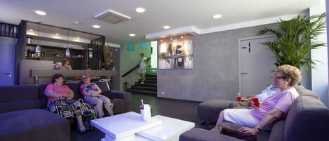 A modern living room with sofas, a coffee table, and a staircase leading to an upper level.