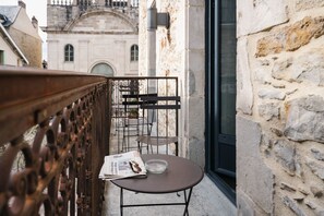 A balcony with a table, chairs, and a newspaper. - Urban Style Les Fleurines (Villefranche-de-Rouergue)