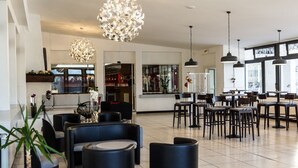 Un hall d’entrée spacieux, doté de mobilier moderne, d’un bar et de grandes fenêtres laissant entrer la lumière naturelle.