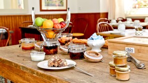 A breakfast buffet with various food items and condiments on a wooden table. - Chez Germaine (Geus-d'Oloron)