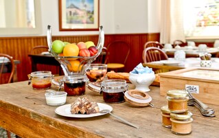 A breakfast buffet with various food items and condiments on a wooden table.