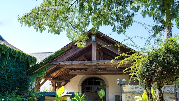 A rustic building with a wooden roof, stone walls, and a covered entrance. - Chez Germaine (Geus-d'Oloron)