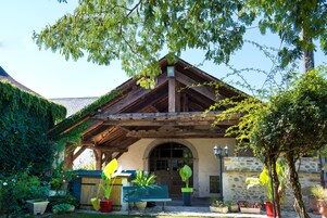 A rustic building with a wooden roof, stone walls, and a covered entrance.