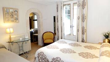 Une chambre d’hôtel avec un lit, une chaise, une table et un radiateur.