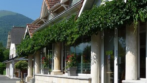 A row of traditional-style buildings with large windows and columns, likely part of a hotel or similar establishment. - L'Ayguelade (Bielle)
