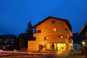 Ein zweistöckiges Holzhaus mit einem Schild, auf dem 'Park Hotel Azalea' steht.