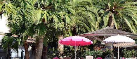 Una piscina al aire libre, cabañas de piscina gratuitas, sombrillas